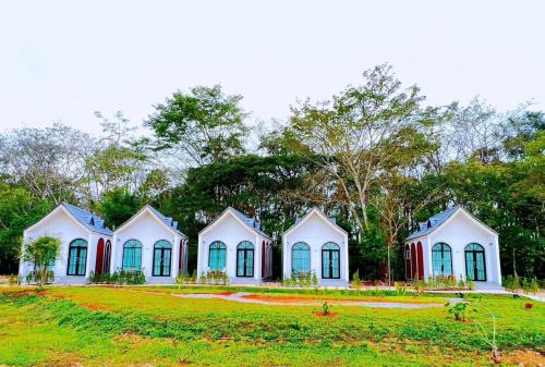 a row of houses on a grass field at คีรีศิลป์ รีสอร์ท เชียงราย (Khirisin Resort Chiang rai) in Ban Nong Salaep