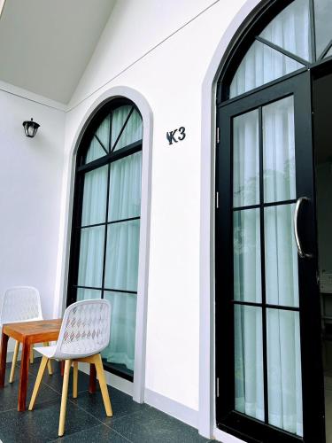 a table and two chairs in a room with windows at คีรีศิลป์ รีสอร์ท เชียงราย (Khirisin Resort Chiang rai) in Ban Nong Salaep