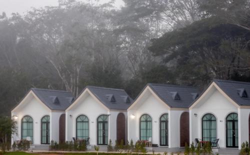 a row of white houses with black roofs at คีรีศิลป์ รีสอร์ท เชียงราย (Khirisin Resort Chiang rai) in Ban Nong Salaep