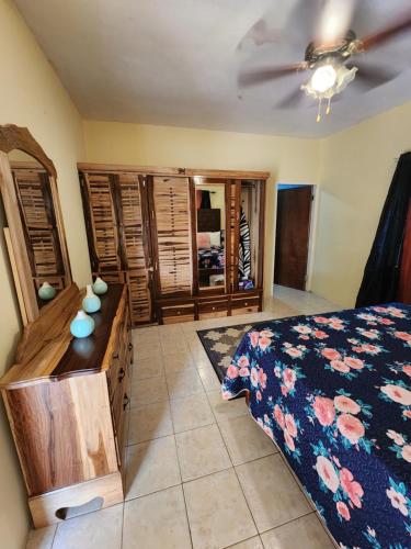 a bedroom with a bed and a dresser and a ceiling at Single Room on Farcas Drive in Mammee Bay