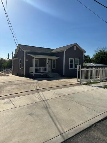 a house with a porch and a white fence at Minutes to Riverwalk, Sleeps 12, Pets Welcome! in San Antonio