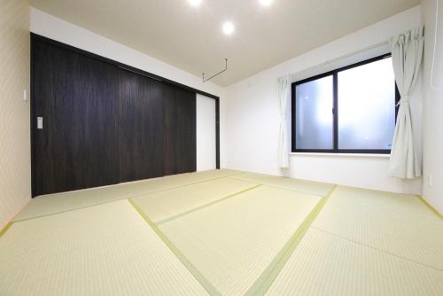 an empty room with a door and a window at COTO Tokyo Sugamo in Tokyo