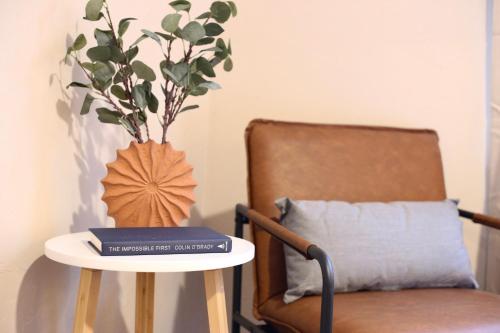 a table with a book on it next to a chair at Nomad Retreat King Bed Boutique Condo w Garage in Gainesville