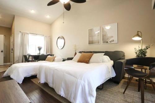 - une chambre avec un grand lit blanc et un canapé dans l'établissement Nomad Retreat King Bed Boutique Condo w Garage, à Gainesville