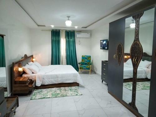 ダカールにあるAppartement 3 chambres toutes climatisées à virageのベッドルーム1室(ベッド1台、鏡、椅子付)