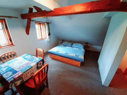 Zimmer mit 2 Betten und einem Tisch in der Unterkunft Apartmán Roubenka Všemily in Jetřichovice