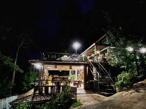 a house with a deck at night at Baan Nhuer Mek บ้านเหนือเมฆ Coffee and Desk on the Cloud in Ban Pang Klang