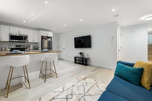 a living room with a blue couch and a kitchen at Beautiful 1 bedroom apartment - private entrance in Moncton
