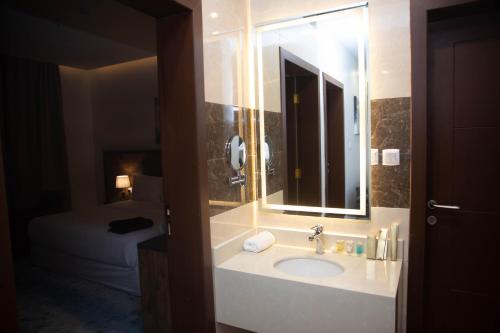 łazienka z umywalką, lustrem i łóżkiem w obiekcie فندق نوفا بارك w Szarurze