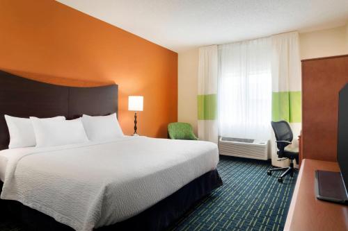 a hotel room with a large bed and a window at Fairfield Inn & Suites by Marriott Champaign in Champaign