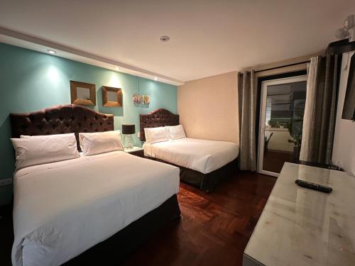 a hotel room with two beds and a window at La Casa del Viajero in Lima