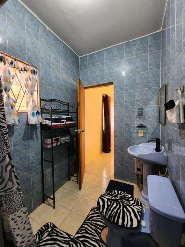 uma casa de banho em azulejos azuis com um lavatório e um chuveiro em Single Room on Farcas Drive em Mammee Bay