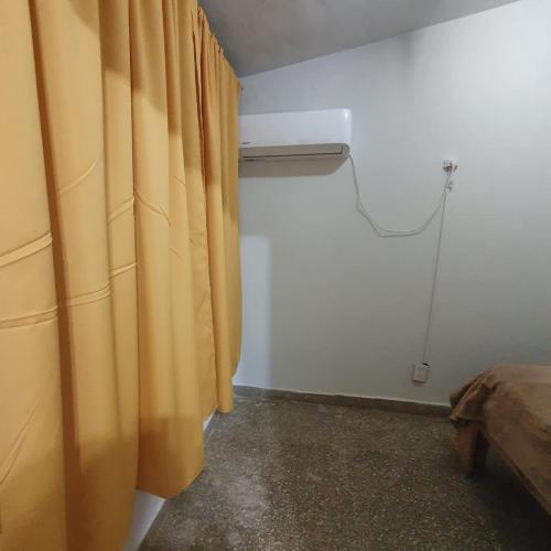 a room with a curtain and a bed and a window at Basic Apart in Paso de los Libres