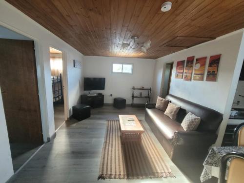 ein Wohnzimmer mit einem Sofa und einem Tisch in der Unterkunft RyG Apartments in San Carlos de Bariloche
