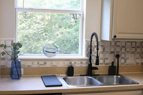 a kitchen sink with a window in a kitchen at Renovated Modern Industrial Suite 2 BR Condo in Gainesville