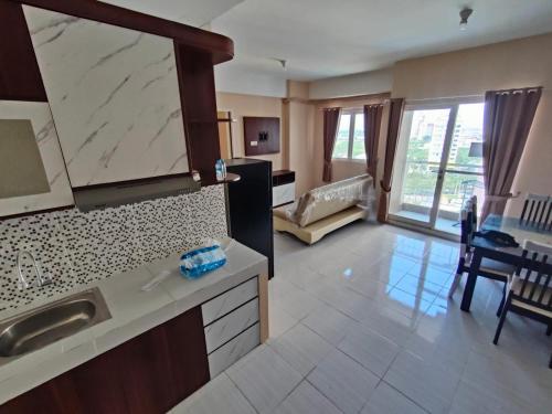 uma cozinha com um lavatório e uma sala de estar em Made Residence and Apartment em Surabaya