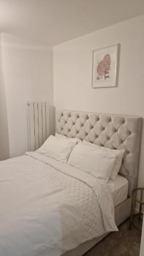 a bedroom with a large bed with white sheets at Stylish Furnished Room In Barking Centre in Barking