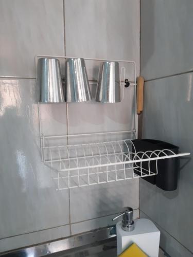 a row of silver pans on a shelf in a kitchen at Pousada do Joaquimxdarc in Natal