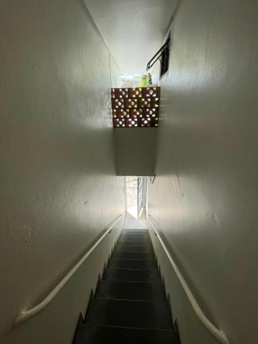 a hallway with a light at the end of a wall at Apartamento Encantador Central in Montes Claros