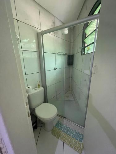 a bathroom with a toilet and a glass shower at Apartamento Encantador Central in Montes Claros