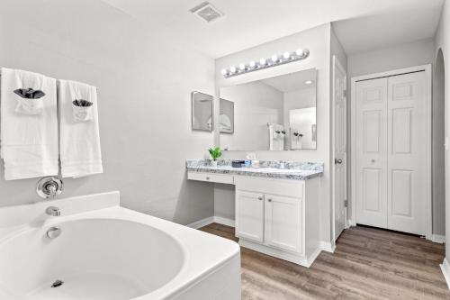 La salle de bains blanche est pourvue d'un lavabo et d'un miroir. dans l'établissement Firepit home-15 min from beach! Family-sized Firepit Retreat, à Palm Coast