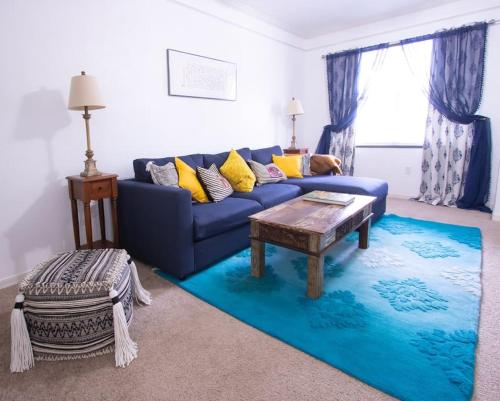 a living room with a blue couch and a blue rug at Modern Boho Condo with a Royal Touch -KING BED in Gainesville