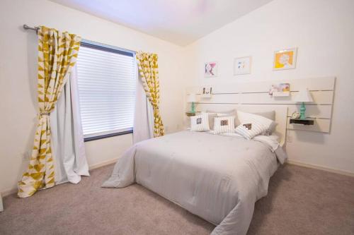 a bedroom with a white bed and a window at Modern Boho Condo with a Royal Touch -KING BED in Gainesville