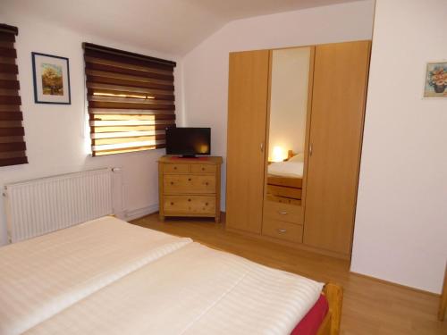 a bedroom with a bed and a dresser and a mirror at Charmantes Dachgeschoss-Refugium, Harz in Wildemann
