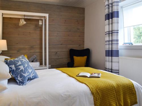 a bedroom with a bed with a wooden wall at Ty Canol in Llansaint