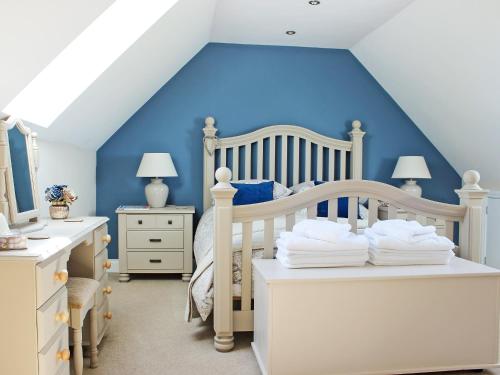 a bedroom with a bed and a blue wall at Pasture View in Barnard Castle