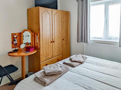a bedroom with a bed and a wooden cabinet at Kingford Lodge in High Bickington