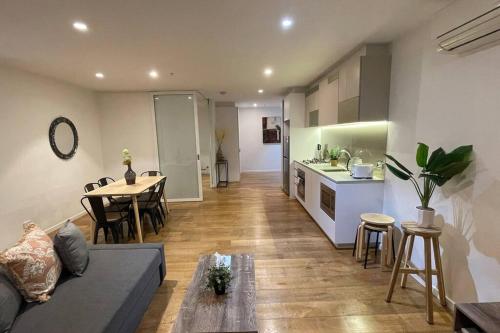 a living room and kitchen with a couch and a table at Nest Apartments on Rose Lane in Melbourne