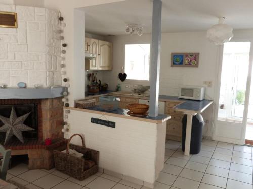 - une cuisine avec un comptoir et une cheminée dans l'établissement Maison La Tranche-sur-Mer, 4 pièces, 6 personnes - FR-1-194-36, à La Tranche-sur-Mer