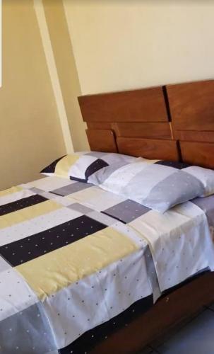 a large bed with a black and white comforter at Alojamiento Cocapata in Quillacollo