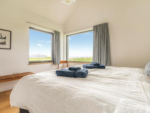 a bedroom with a large bed with two blue towels on it at The Two Byres in Trumpan