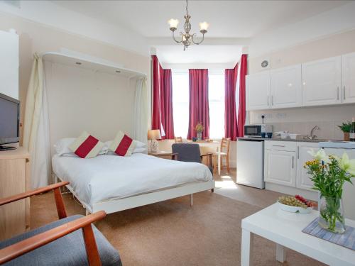 um quarto com uma cama grande e uma cozinha em Apartment Seven - Uk39843 em Paignton