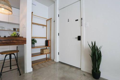 a hallway with a pivot door and a plant at ConCrete Suite 5 Min Walk to Shands UF in Gainesville