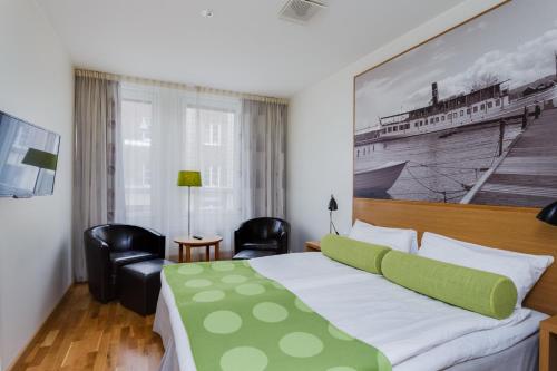 a bedroom with a bed with a green and white bedspread at Sure Hotel by Best Western City Jonkoping in Jönköping