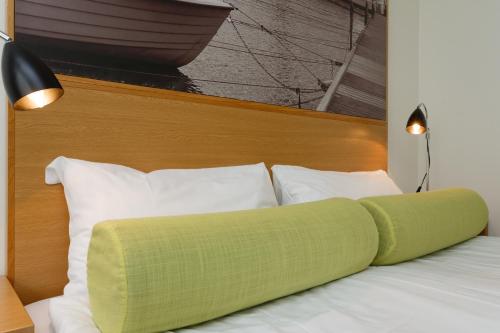 a bed with a green pillow on top of it at Sure Hotel by Best Western City Jonkoping in Jönköping