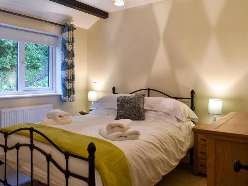 1 dormitorio con 1 cama con toallas en May Cottage - Uk12970, en Settle