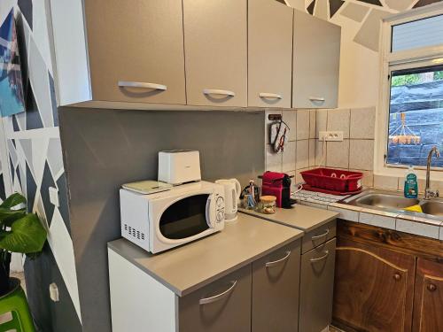 a kitchen with a microwave on top of a counter at VHouse 2 in Bora Bora