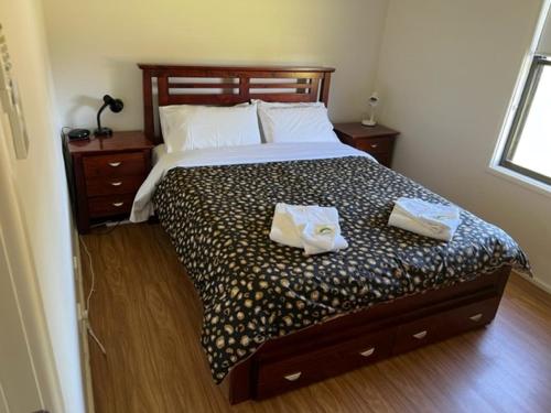 a bedroom with a bed with two towels on it at RIVER DOWNS COTTAGE in Clarence Town