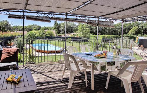 Un patio con mesa y sillas y una piscina. en Gorgeous Home In Aubignan, en Aubignan