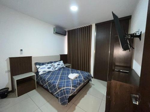 a small bedroom with a bed and a television at Departamentoo nuevo amoblado cerca a UAGRM, con excelente vista in Santa Cruz de la Sierra