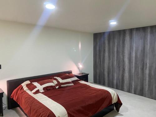 1 dormitorio con 1 cama con manta roja y blanca en Bonito y Cómodo Departamento, en Zacatecas