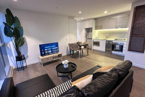 a living room with a couch and a table and a kitchen at Nest Apartments on Rose Lane in Melbourne