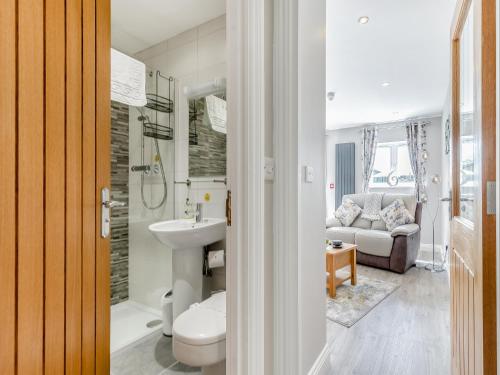 een badkamer met een wastafel, een toilet en een bank bij The Dairy At Crich Lane Farm in Wingfield