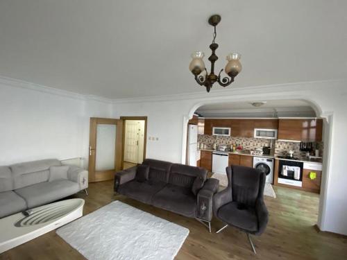 MezitliにあるLuxury apartment with sea viewのリビングルーム(ソファ、椅子付)、キッチンが備わります。