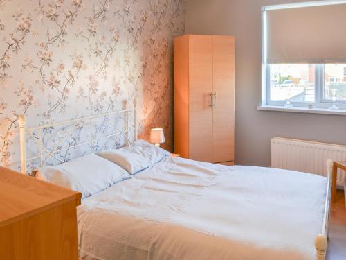 ein Schlafzimmer mit einem weißen Bett und einem Fenster in der Unterkunft Smugglers Retreat in Woodhorn