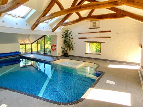 a large swimming pool in a house with a ceiling at Ysgubor Ganol in Llanglydwen